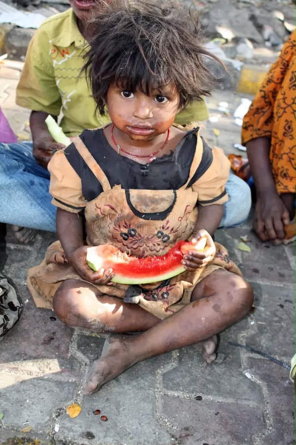 A young child eating watermelon during a food distribution